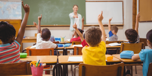 Classroom with students raising their hands