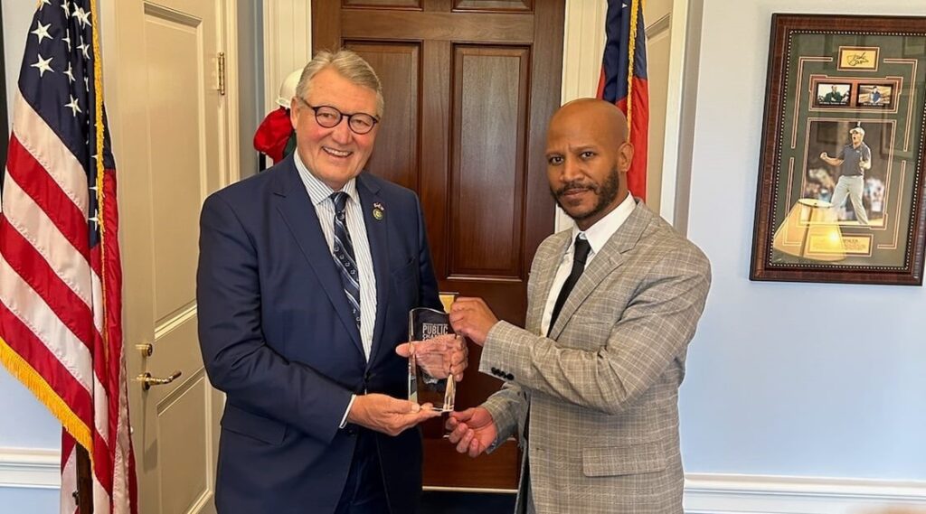 Photo of school leader in Congress giving award in 2023